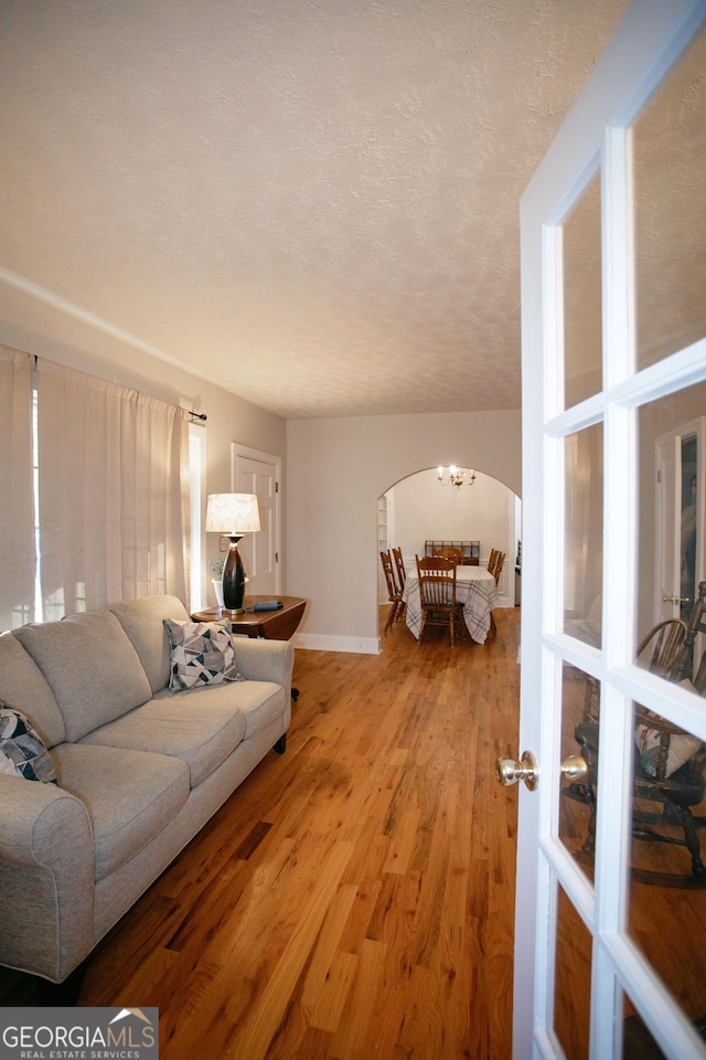 living room with light hardwood / wood-style floors and a textured ceiling