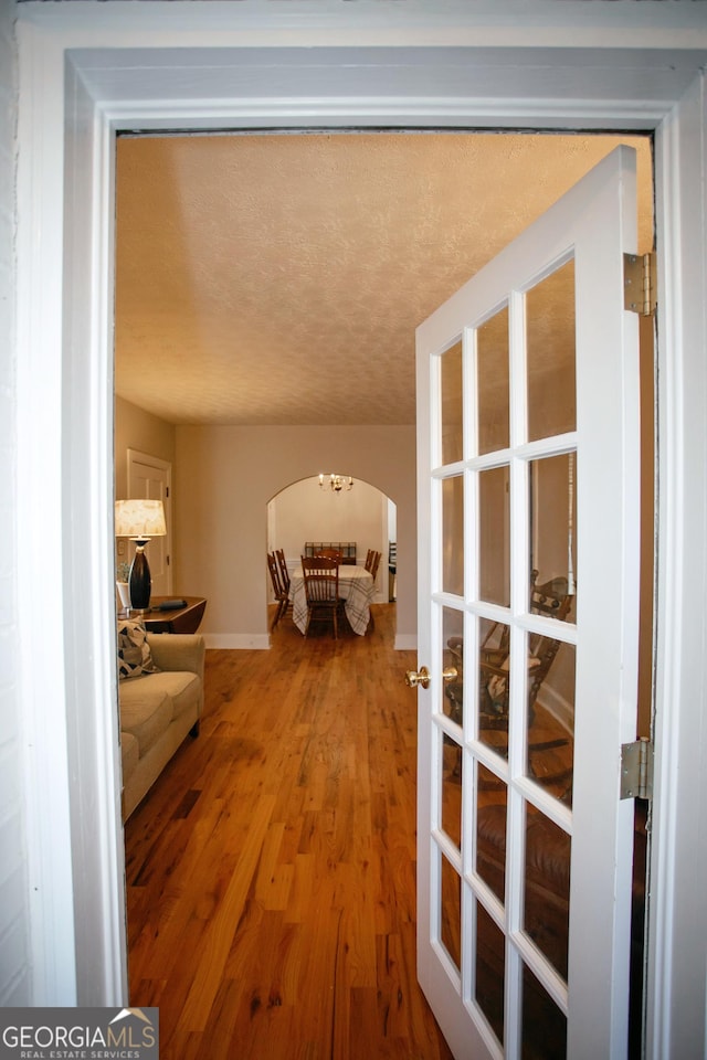 hallway featuring hardwood / wood-style flooring and a textured ceiling