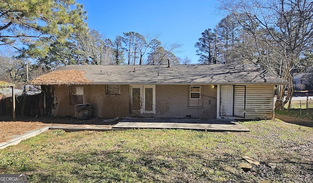 back of property featuring a patio area and a lawn