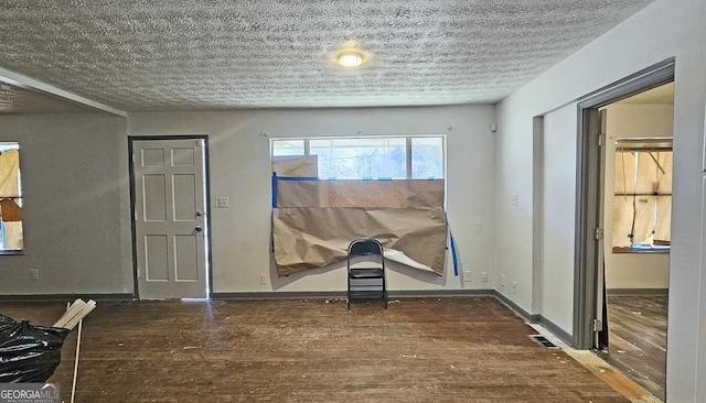 entrance foyer with dark hardwood / wood-style flooring and a textured ceiling