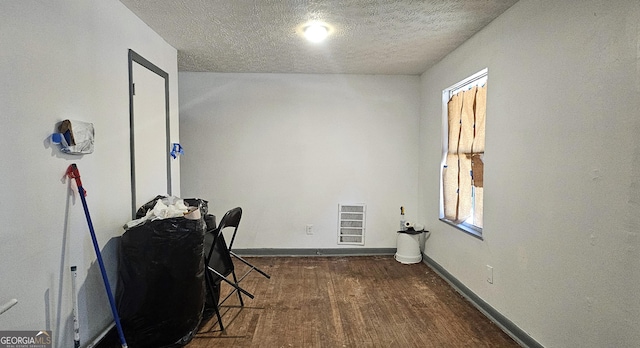 home office featuring dark wood-type flooring and a textured ceiling