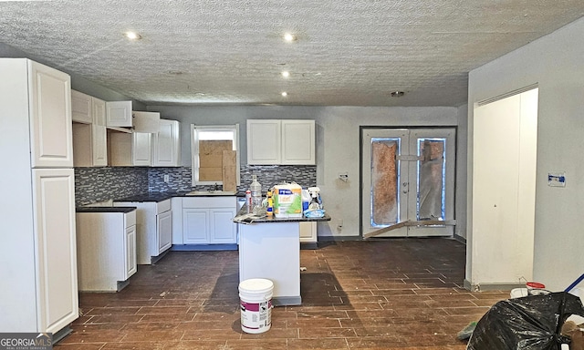 kitchen featuring a center island, sink, white cabinets, and decorative backsplash