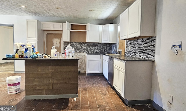 kitchen with dark wood-type flooring, white cabinetry, tasteful backsplash, a kitchen island, and stainless steel dishwasher