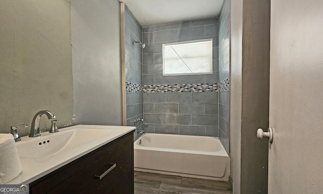 bathroom featuring vanity, hardwood / wood-style flooring, and tiled shower / bath