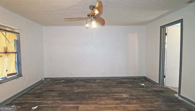 spare room featuring plenty of natural light, dark hardwood / wood-style floors, and a textured ceiling