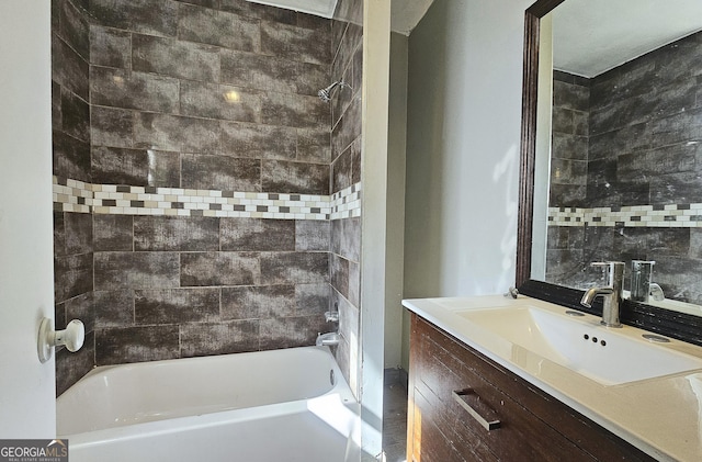 bathroom with tiled shower / bath combo and vanity