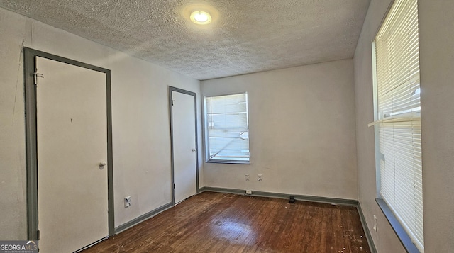 unfurnished bedroom featuring dark wood-type flooring and a textured ceiling