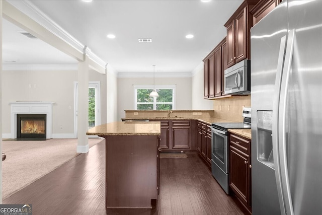 kitchen featuring appliances with stainless steel finishes, tasteful backsplash, light stone countertops, ornamental molding, and decorative light fixtures