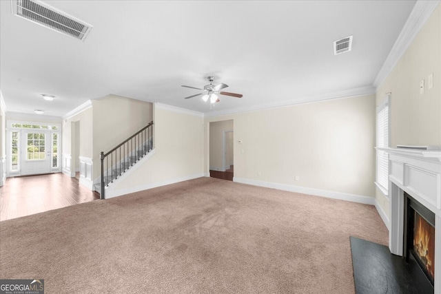 unfurnished living room with crown molding, ceiling fan, and carpet