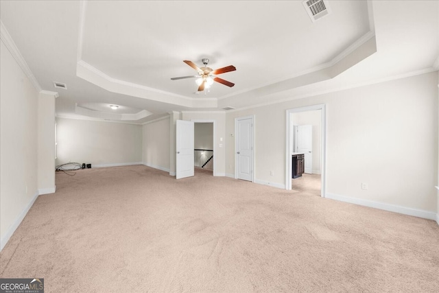 unfurnished bedroom with light carpet, ornamental molding, a raised ceiling, and ceiling fan