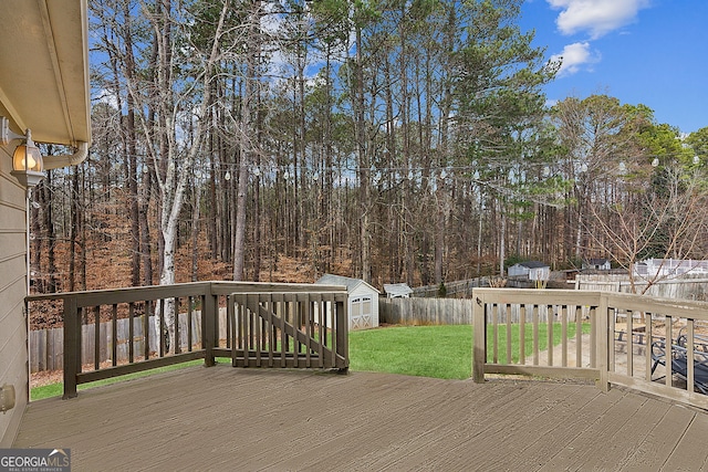 wooden deck with a shed and a yard