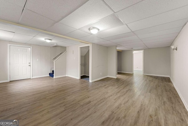 basement featuring hardwood / wood-style flooring and a paneled ceiling