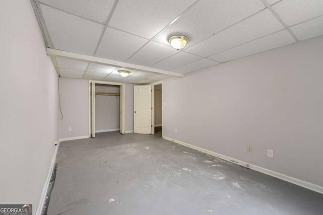 interior space featuring a paneled ceiling, a closet, and concrete floors