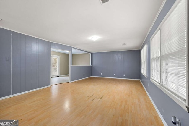 spare room with crown molding and light hardwood / wood-style flooring