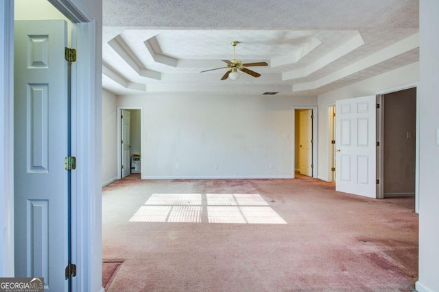 carpeted empty room featuring ceiling fan, a tray ceiling, and a textured ceiling