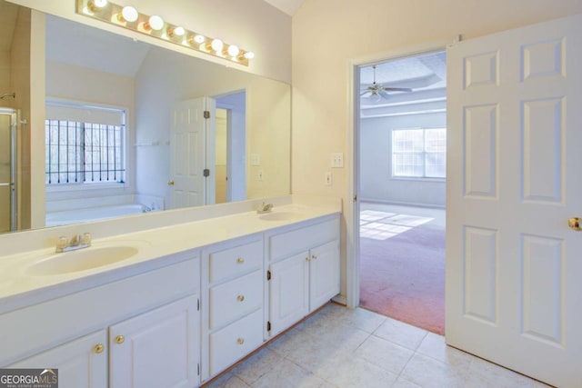 bathroom with vaulted ceiling, vanity, a washtub, ceiling fan, and tile patterned floors