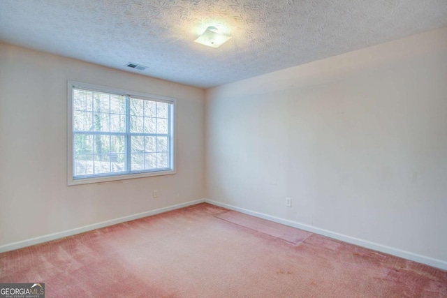 unfurnished room featuring light colored carpet and a textured ceiling