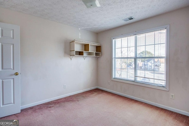 unfurnished room featuring light carpet and a textured ceiling