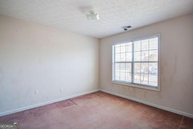 carpeted spare room with a textured ceiling