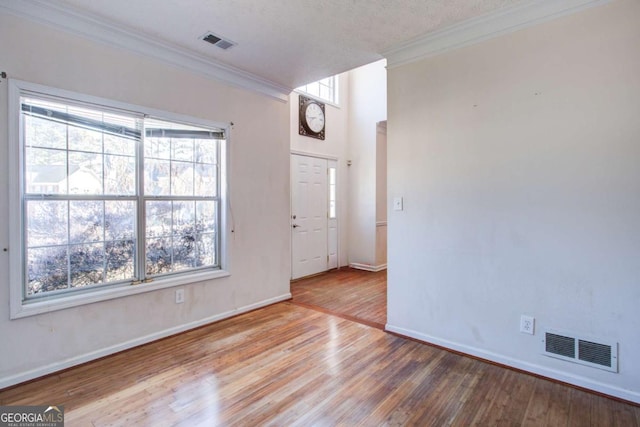 foyer with crown molding, plenty of natural light, and hardwood / wood-style floors