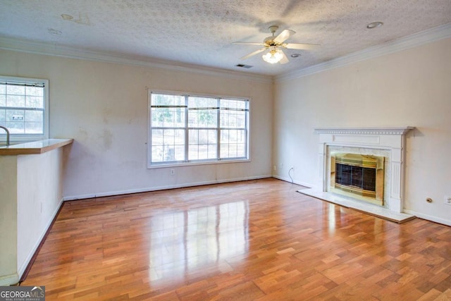 unfurnished living room featuring a fireplace, light hardwood / wood-style flooring, and a wealth of natural light