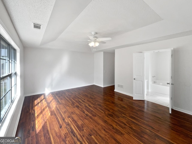 unfurnished room featuring ceiling fan, dark wood-type flooring, and a textured ceiling