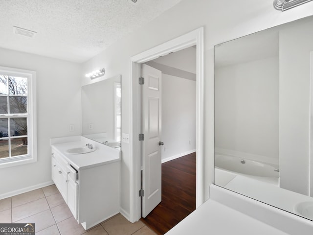 bathroom featuring vanity, tile patterned floors, and a textured ceiling