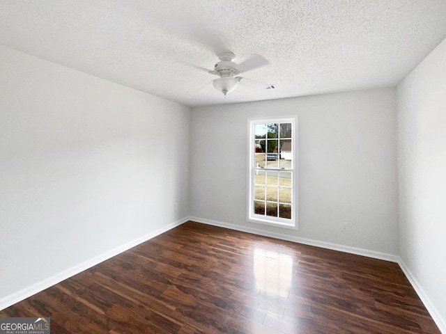 empty room featuring a textured ceiling, dark hardwood / wood-style floors, and ceiling fan