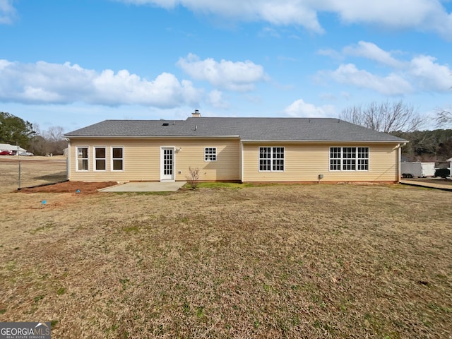 rear view of house with a lawn and a patio area