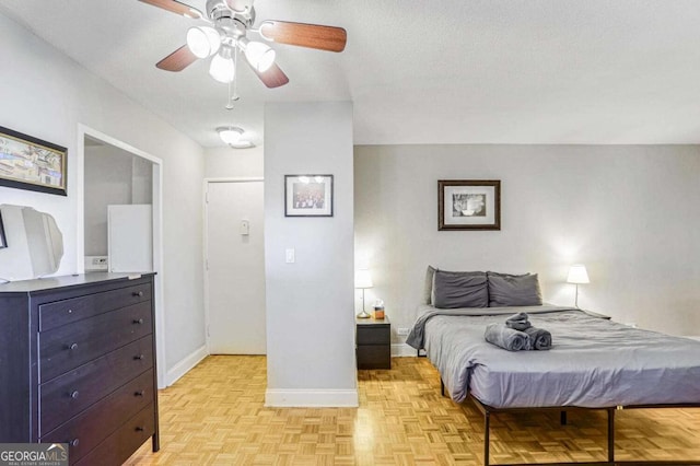 bedroom with ceiling fan, a textured ceiling, and light parquet flooring