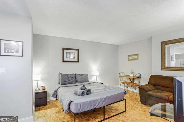 bedroom featuring a textured ceiling and light parquet floors