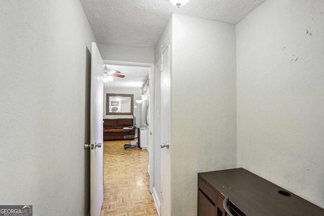 hallway with a textured ceiling and light parquet flooring