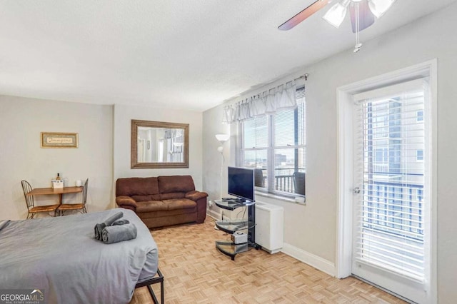 bedroom featuring ceiling fan, a textured ceiling, and light parquet flooring