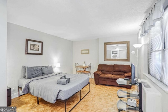 bedroom with light parquet flooring and a textured ceiling