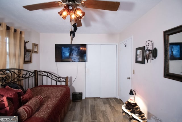 bedroom with multiple closets, hardwood / wood-style floors, and ceiling fan