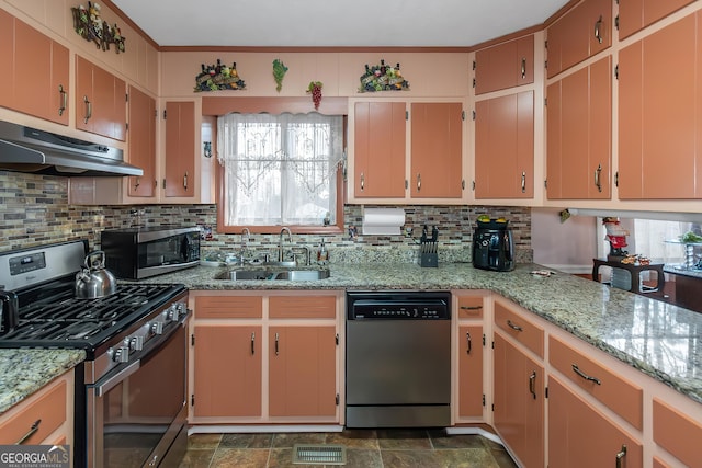 kitchen with sink, appliances with stainless steel finishes, light stone countertops, range hood, and backsplash