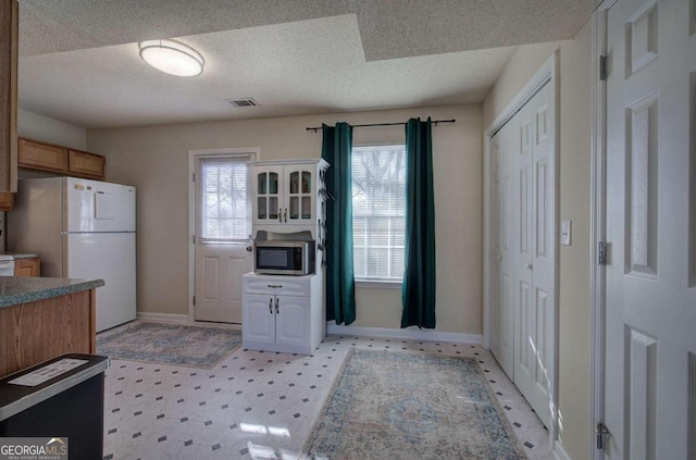 kitchen featuring a textured ceiling and white fridge