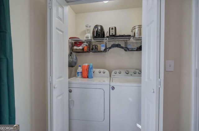 clothes washing area featuring washer and dryer and a textured ceiling