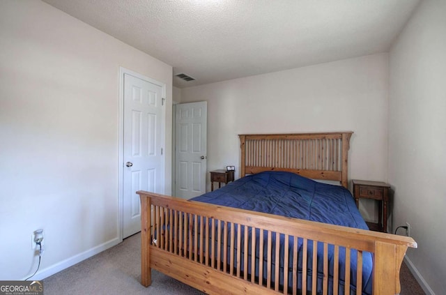 bedroom featuring carpet floors and a textured ceiling