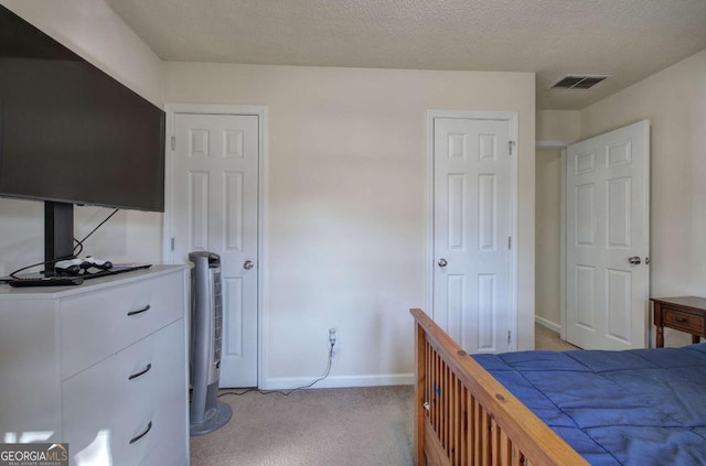 carpeted bedroom featuring a textured ceiling