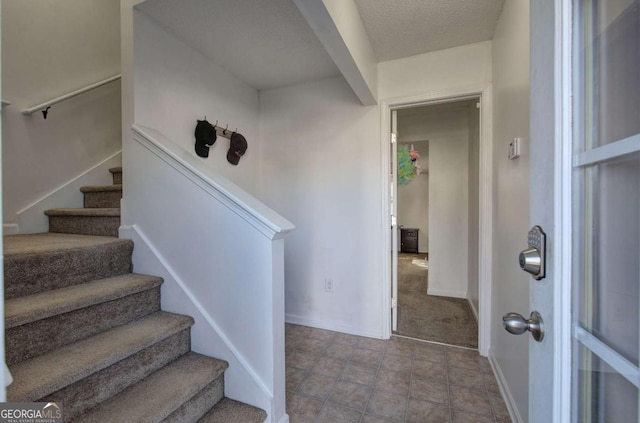 staircase with a textured ceiling