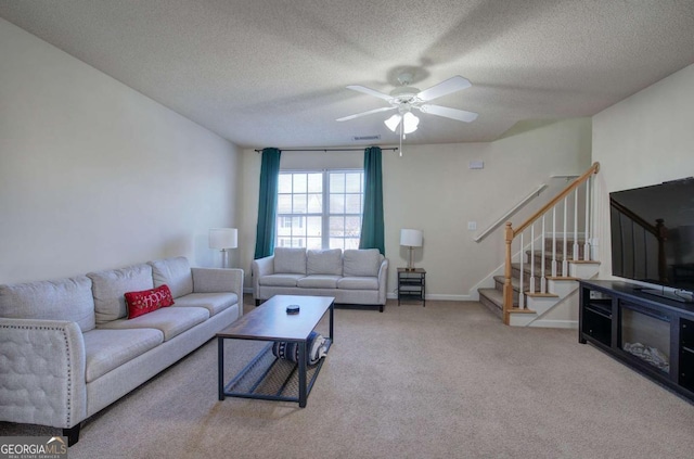 living room featuring ceiling fan, carpet flooring, and a textured ceiling