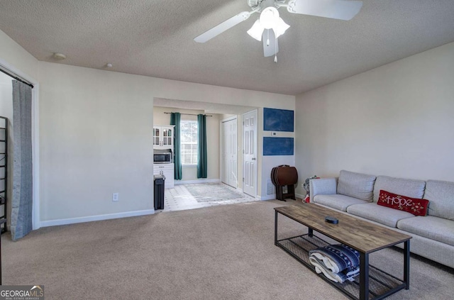 carpeted living room with ceiling fan and a textured ceiling