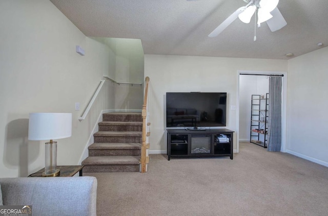 carpeted living room featuring a textured ceiling and ceiling fan