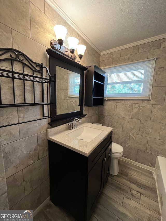 bathroom featuring hardwood / wood-style flooring, crown molding, vanity, a textured ceiling, and toilet