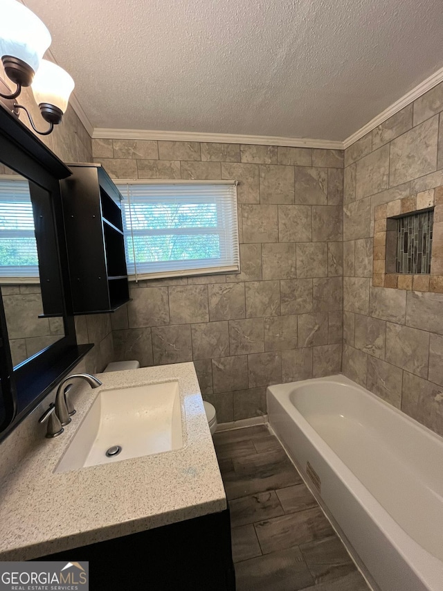 bathroom with crown molding, toilet, a bathing tub, and a textured ceiling