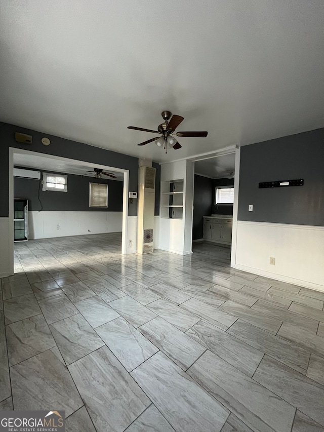 unfurnished living room with a healthy amount of sunlight and ceiling fan