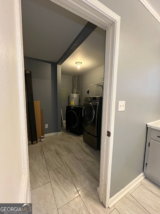 clothes washing area featuring washing machine and dryer and water heater