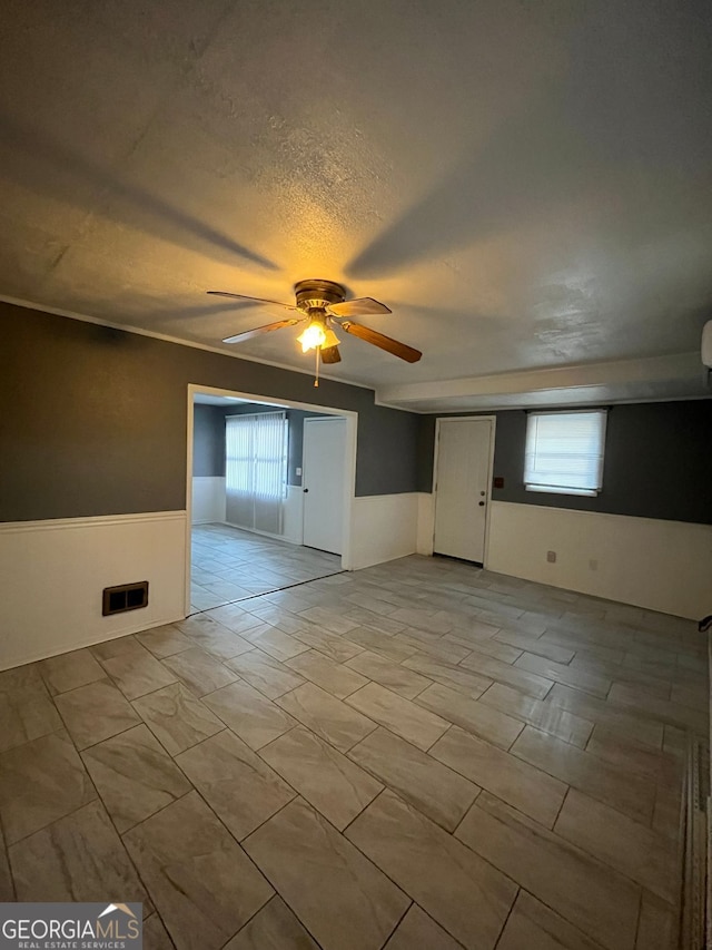 empty room featuring ceiling fan and a textured ceiling