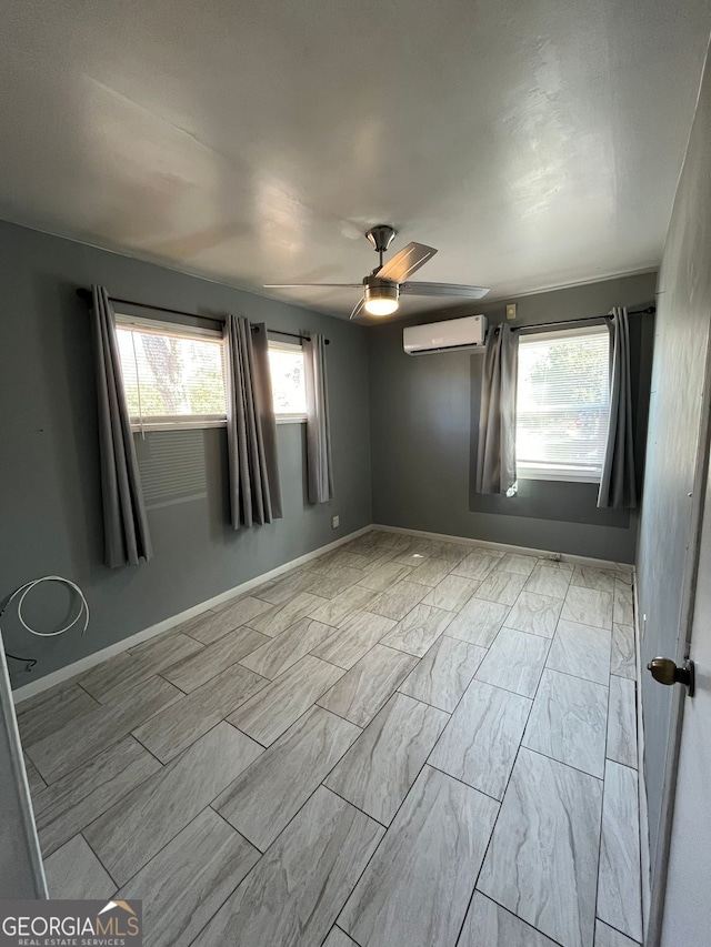 spare room featuring ceiling fan, plenty of natural light, and a wall mounted AC